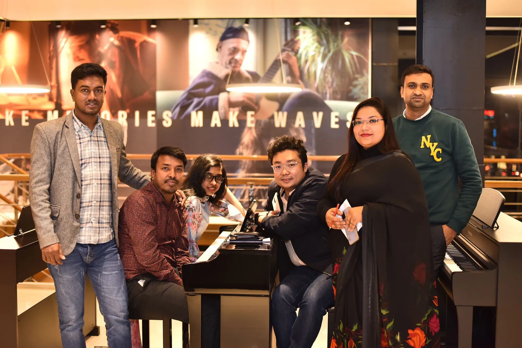 A group gathered around a grand piano in a music showroom