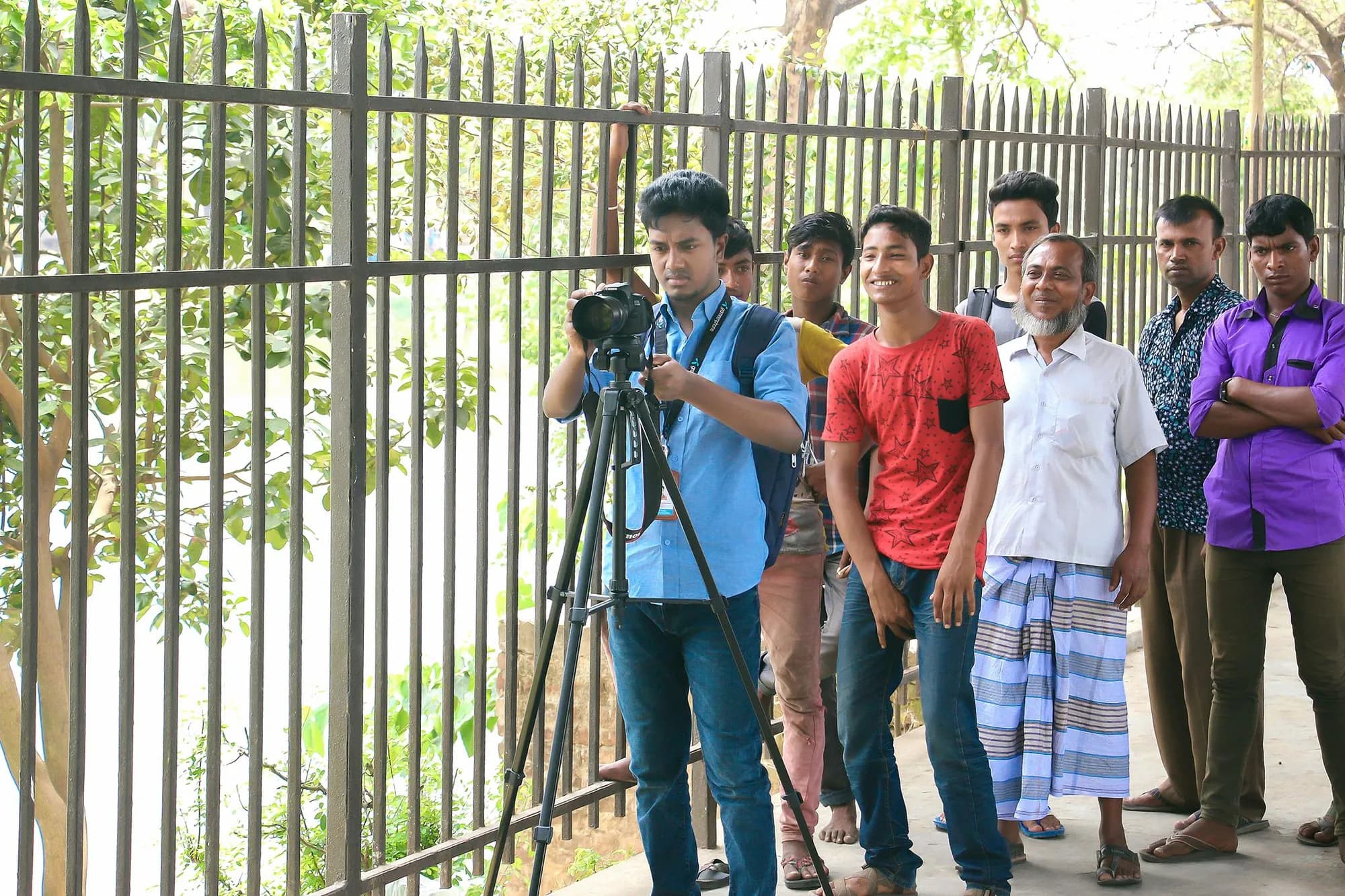 Razu Rahman filming outdoors with a camera on a tripod