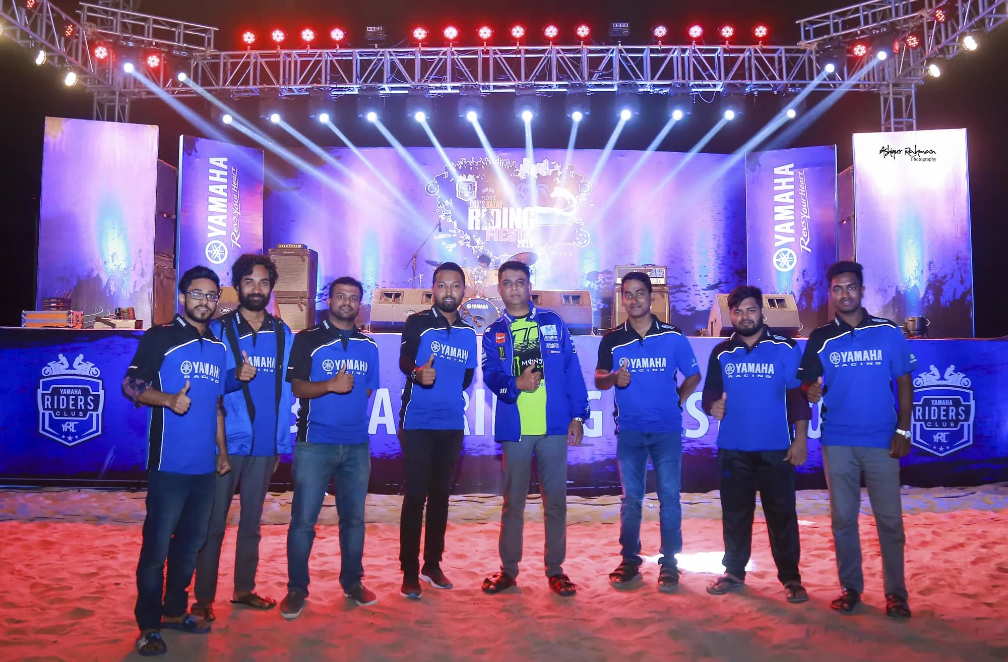 Yamaha team on stage under blue event lighting